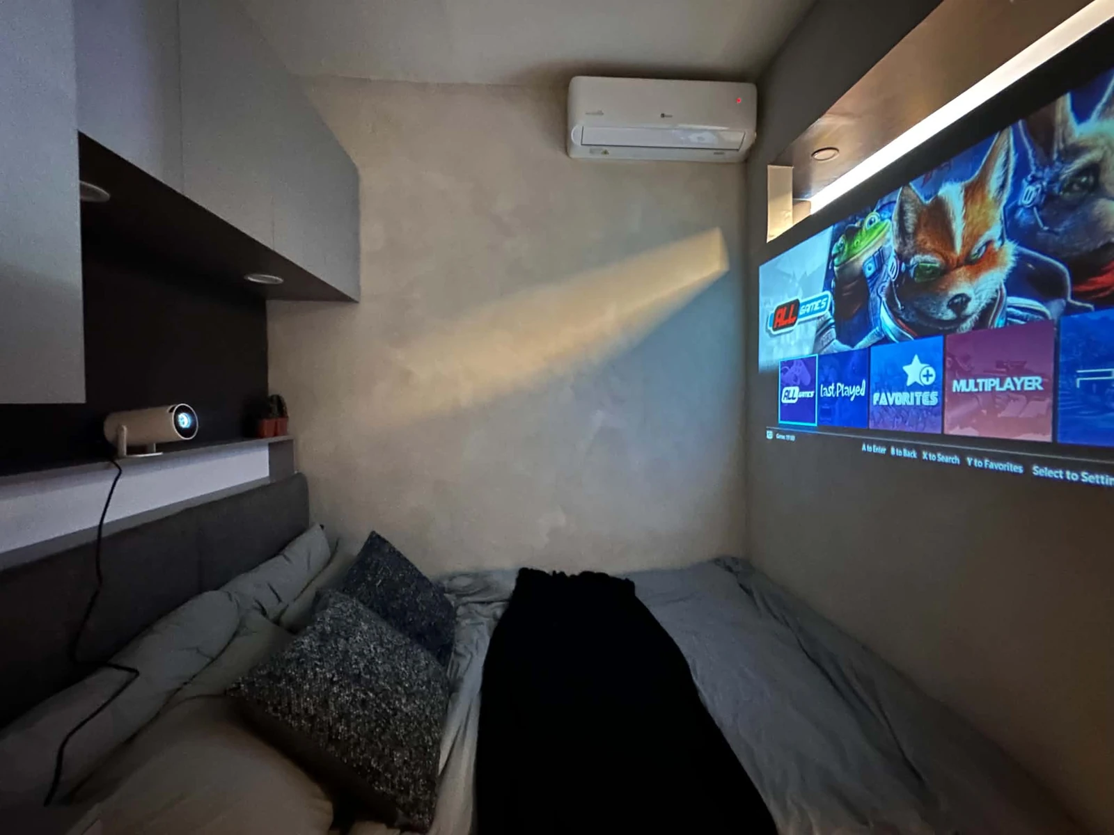 Bedroom projector displaying the retro gaming menu at MONO/LITH