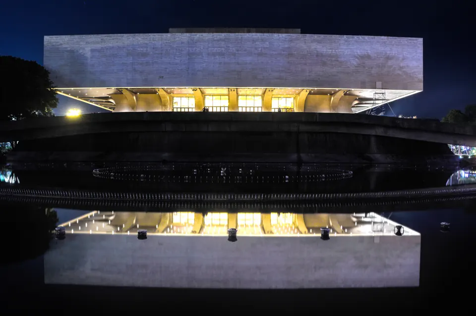 CCP main building at night reflected in its front pool